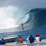 surfer in curl towards boats